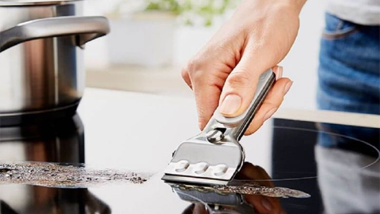 Dùng dao cạo chuyên dụng làm sạch vết cháy trên mặt bếp từ