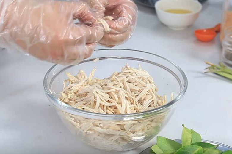 Gà luộc chín vớt ra ngâm nước lạnh rồi xé sợi.