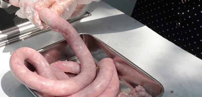 Cho thịt được đã được sơ chế bắt đầu nhồi vào vỏ xúc xích