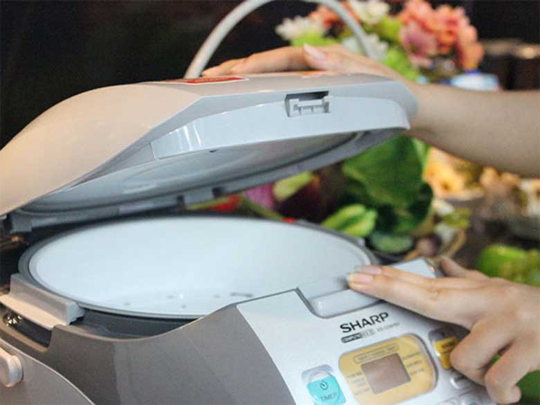 Cách vệ sinh nồi cơm điện ấn nhẹ giữ nắp mở
