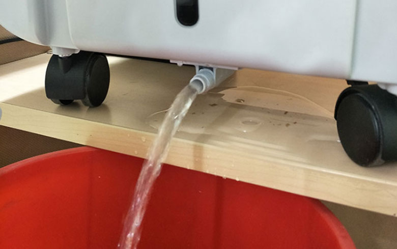 Cách vệ sinh quạt điều hòa: Xả nước trong bình